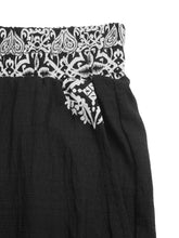 Black boho print wide leg pants with white paisley elastic waistband and matching embroidered pocket detail