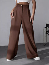 Brown high-waisted wide leg pleated pants with tailored fit and subtle waistband pleats for elegant wear
