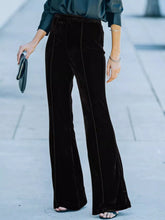 High-waisted wide leg velvet pants in black velvet with subtle side seam detailing and flare silhouette