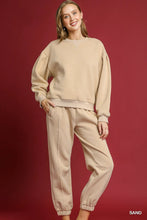 Beige oversized sweatshirt with relaxed fit and ribbed cuffs paired with umgee fleece jogger pants with drawstring waist allows adjustable comfort