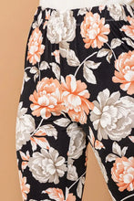 Black flare pants with peach and white peony floral pattern made from wrinkle-free stretch fabric with elastic waist