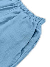 Light blue linen shorts with elastic waistband and textured weave complementing floral wide leg pants style