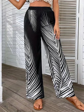 Black wide leg pants with bold white palm leaf pattern offering stylish printed wide-leg pants design