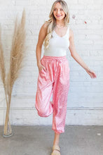 Pink satin leopard print joggers with wide-leg cut and drawstring waist suitable for machine wash cold care