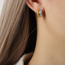 18k gold-plated and titanium steel two-tone hoop earrings on ear
