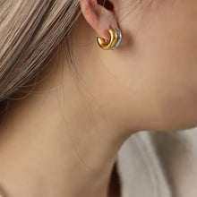 18k gold-plated and titanium steel two-tone hoop earring on ear