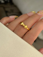 Delicate 18K gold-plated bow knot ring on manicured finger