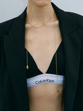 Open black blazer over Calvin Klein bralette with 18k gold-plated chain pendant necklace