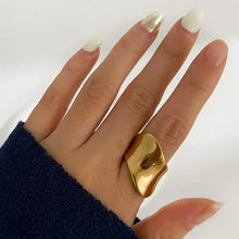 Hand with 18k gold-plated geometric wide band ring and white metallic nails