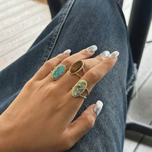 Hand wearing three 18k gold-plated tiger’s eye open rings