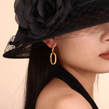 Woman in black floral hat with 18k gold-plated titanium steel annulus earrings
