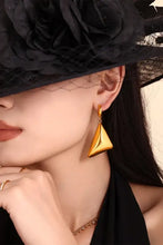 Woman in black hat and veil wearing 18k gold-plated triangle dangle earrings