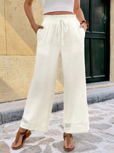 Cream-colored wide leg pants with drawstring waistband and crochet trim hem offering a perfect fit and pockets