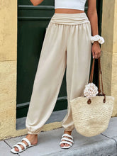 Beige ruched high waist joggers made of soft flowing fabric with elastic cuffs and high waist design