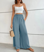 Blue high-waisted wide leg pants with gathered elastic waistband and subtle vertical pleats for elegant wear
