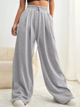 Gray wide leg pants with drawstring waist and elastic cuffs made of soft sweatpant material for comfortable wear