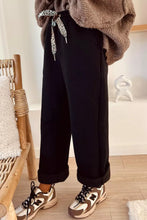 Black high-waisted straight pants with adjustable leopard-print drawstring waist and care instructions for machine wash cold
