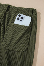 Olive green high waist square pockets corduroy pants with front pocket holding a white smartphone