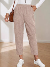 Beige corduroy elastic waist cropped pants with a relaxed fit and tapered legs for casual wear