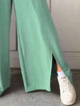 Mint green slit wide leg pants made of soft flowing fabric featuring a side slit for elegant movement