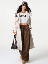 Black leather hobo bag with structured shape and top handle styled with wide leg drawstring pants