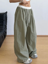 Olive green wide leg drawstring casual pants with white elastic waistband and adjustable leg drawstring detail