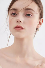 Young woman wearing 2 carat moissanite sterling silver drop earrings