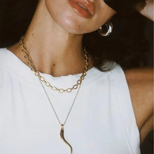 Woman in white top with 18K gold-plated pepper pendant necklace