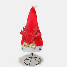 Red 2-piece antler Christmas hat with sparkly reindeer antlers, gold bow, pompom, and green tree accents