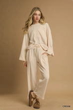 Cream-colored relaxed-fit umgee wide leg pants with a tie-waist top loungewear set ideal for comfortable wear