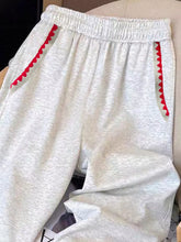 Light gray heathered casual loose fit sweatpants with red zigzag loose fit embroidered trim along side pockets