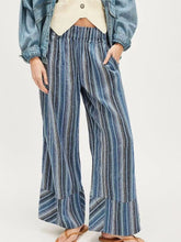 Striped wide leg denim-like fabric pants with vertical blue and white stripes and ruffled hem