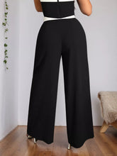 Black high-waisted wide leg pants with a contrasting white waistband perfect for stylish wide leg wear