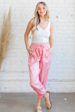 Pink satin leopard print joggers in a relaxed fit made from smooth satin material suitable for machine wash cold care