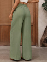 Light green wide leg drawstring waist pants with pleated texture and scalloped hem for stylish comfort