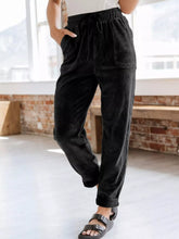 Black relaxed fit corduroy pants with elastic waistband and drawstring for comfortable casual wear