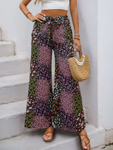 Floral high rise wide leg pants with patchwork black pink and green floral pattern and small blossoms