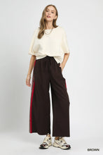 Umgee wide leg pants featuring brown fabric with a drawstring waist and red contrast side trim stripes