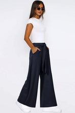 Navy blue tied wide leg pants featuring a tied waistband and side pockets for comfortable wear