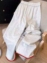 Light gray heathered casual loose fit embroidered sweatpants with red pom-pom trim along the cuffs