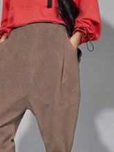 Beige textured wool blend loose fit harem pants with tapered fit and subtle seam detailing with pockets