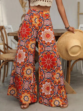 Printed wide leg pants featuring vibrant red and orange floral patterns with a high waist in lightweight fabric