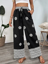 Black wide leg pants with white geometric embroidery and lace trim at waistband and hem boho print wide leg pants