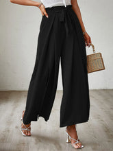 Black high-waisted wide leg pants with a tied belt and pleated front for a stylish and comfortable fit