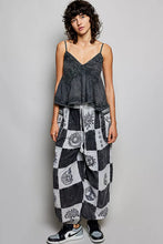 Black and white patchwork wide-leg jogger pants in soft cotton fabric featuring geometric and sun motifs
