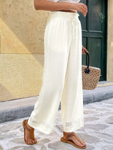 Cream-colored wide leg pants with drawstring waist and crochet trim offering a perfect fit and functional pockets