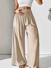 Beige smocked waist wide leg pants with high waist smocked elastic waistband and side pockets for comfortable wear
