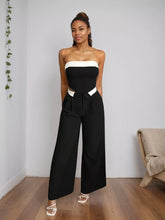 Black and white strapless jumpsuit with wide leg pants and a contrasting white band at the waistline featuring wide leg pants