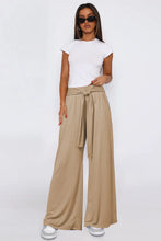 Beige tied pocketed wide leg pants with self-tie waistband and pockets in a flowy wide leg design