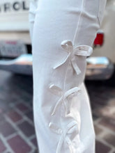 White wide-leg pants with delicate fabric ties forming bows along the side seam for a perfect fit